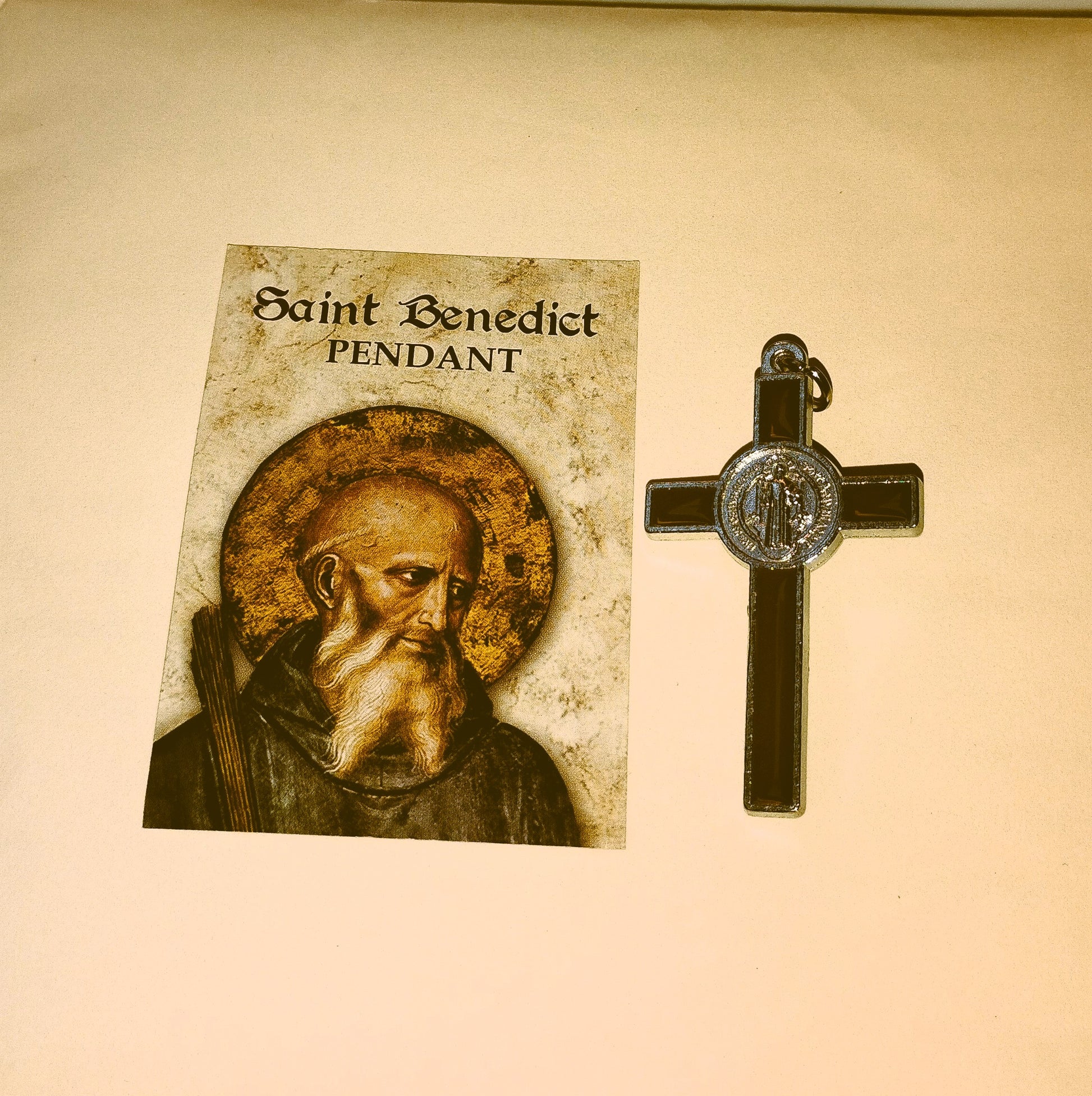 Saint Benedict crucifix with an illustration of the saint on a beige background