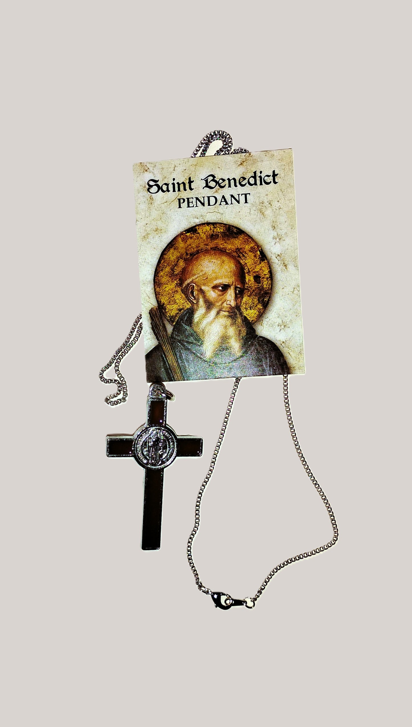 Saint Benedict pendant with silver chain and a picture of St. Benedict on a light gray background